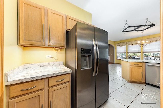 kitchen featuring light tile patterned floors, arched walkways, appliances with stainless steel finishes, light countertops, and a chandelier