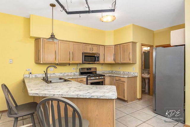 kitchen featuring stainless steel appliances, a peninsula, a sink, light countertops, and a kitchen bar