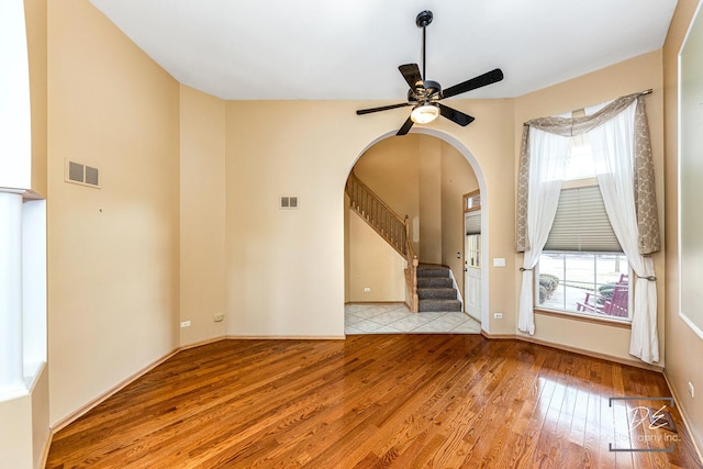 empty room with hardwood / wood-style floors, plenty of natural light, and visible vents