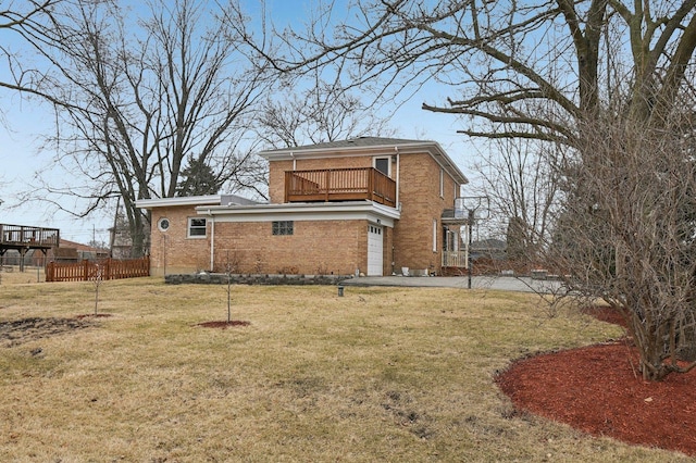 exterior space with driveway, a balcony, fence, a yard, and brick siding