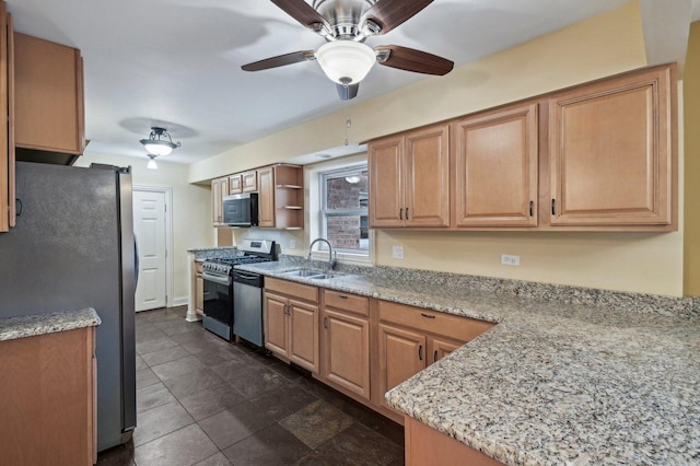 kitchen with stainless steel appliances, light stone counters, and a sink