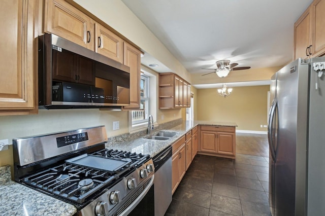 kitchen with light stone counters, a peninsula, stainless steel appliances, open shelves, and a sink