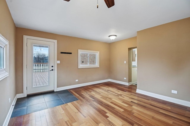 doorway with ceiling fan, baseboards, and wood finished floors