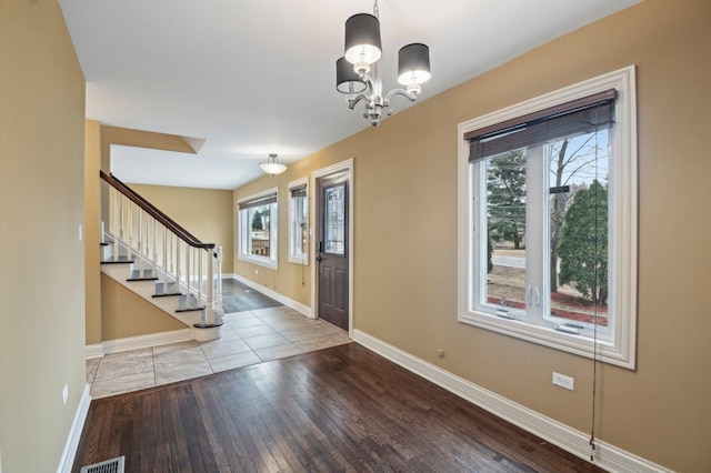 entrance foyer with plenty of natural light, visible vents, baseboards, and hardwood / wood-style floors