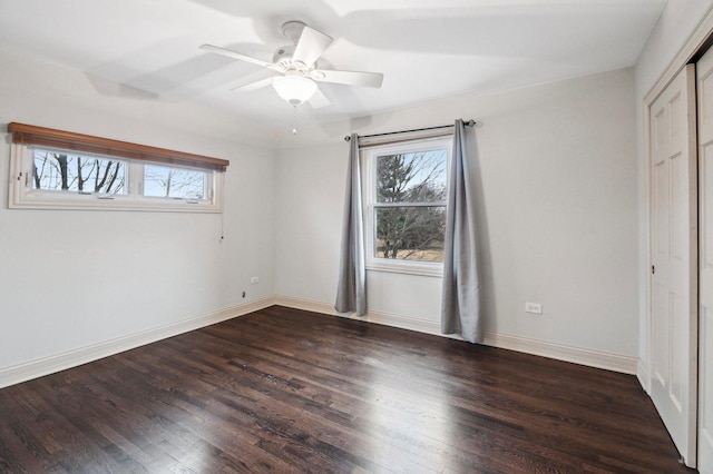 unfurnished bedroom with a closet, wood finished floors, a ceiling fan, and baseboards