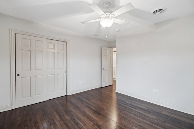 unfurnished bedroom featuring a closet, wood finished floors, visible vents, and baseboards