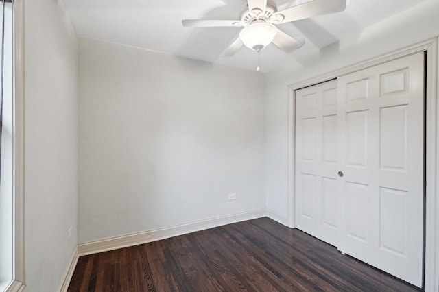 unfurnished bedroom featuring dark wood-style floors, a closet, ceiling fan, and baseboards