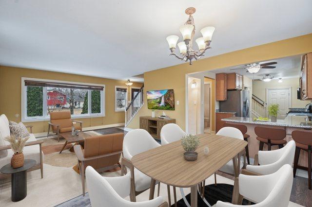 dining area featuring a notable chandelier and stairway