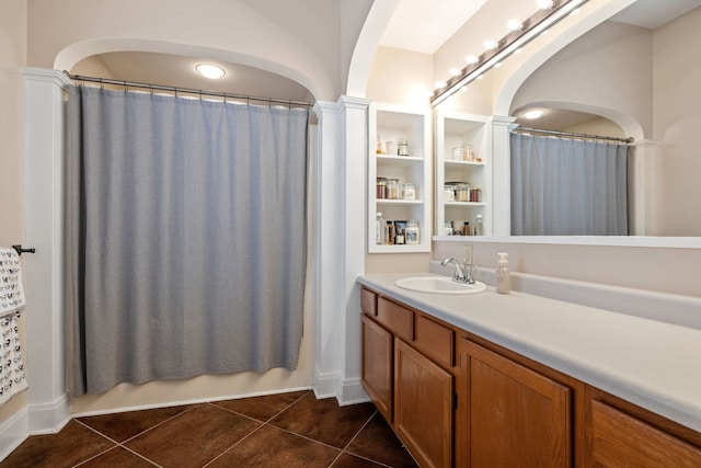 bathroom with tile patterned flooring, decorative columns, and vanity