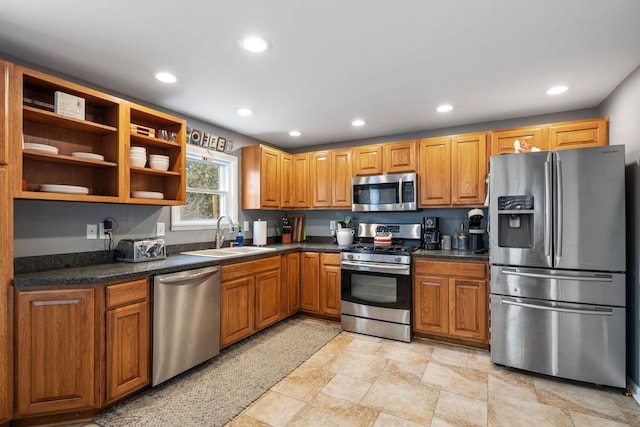 kitchen with stainless steel appliances, dark countertops, a sink, and recessed lighting