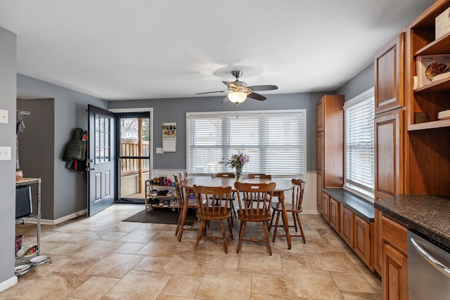 dining space with baseboards and a ceiling fan