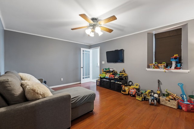 living room featuring baseboards, ceiling fan, ornamental molding, and wood finished floors