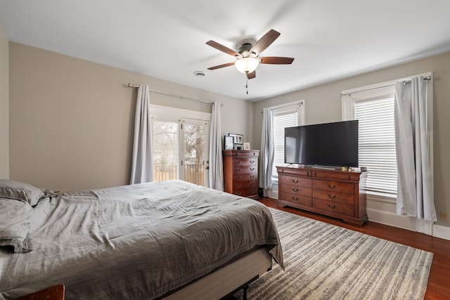 bedroom with ceiling fan, multiple windows, visible vents, and dark wood-style flooring