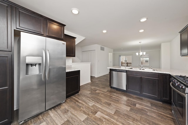 kitchen with dark brown cabinetry, visible vents, appliances with stainless steel finishes, dark wood-type flooring, and a sink