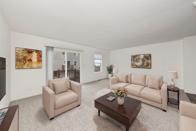 living area featuring baseboards and light colored carpet