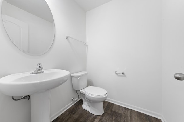 bathroom featuring baseboards, toilet, and wood finished floors