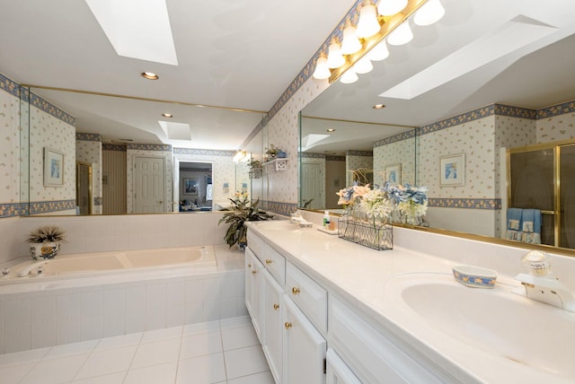 bathroom with a skylight, a garden tub, a stall shower, a sink, and wallpapered walls