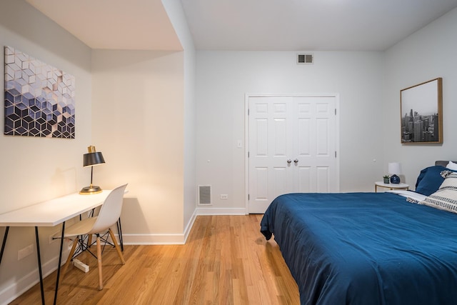 bedroom featuring light wood-type flooring, visible vents, and baseboards