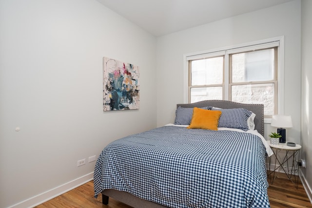 bedroom featuring baseboards and wood finished floors