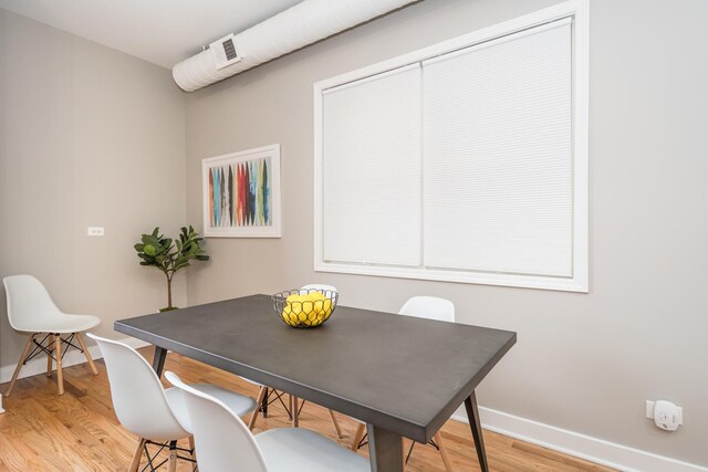 dining space featuring light wood-style flooring and baseboards