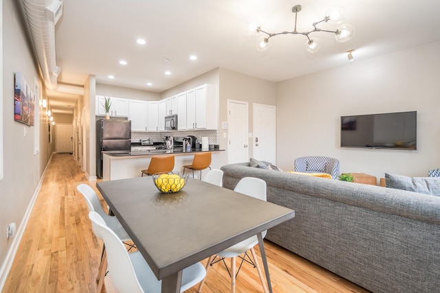 dining area with recessed lighting, light wood-style flooring, and baseboards