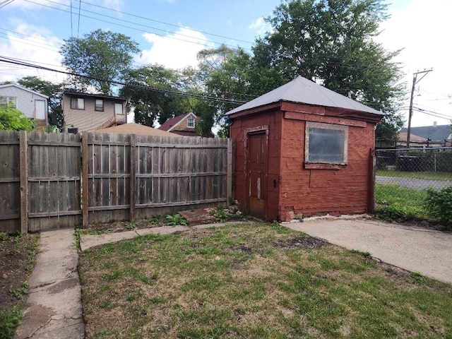 view of yard featuring a fenced backyard, an outdoor structure, and a storage unit