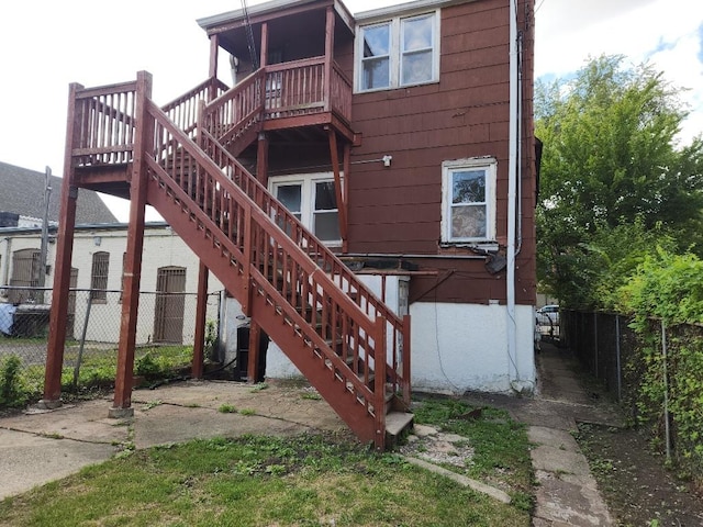 rear view of house featuring stairs and fence