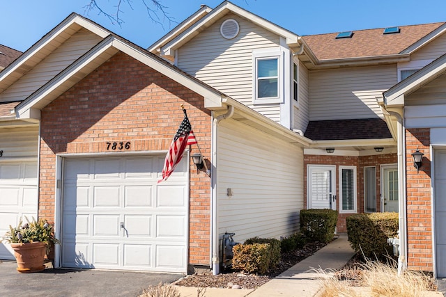 view of home's exterior with a garage, brick siding, and a shingled roof