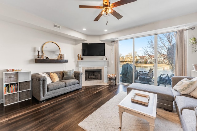 living room featuring visible vents, a tiled fireplace, wood finished floors, recessed lighting, and ceiling fan