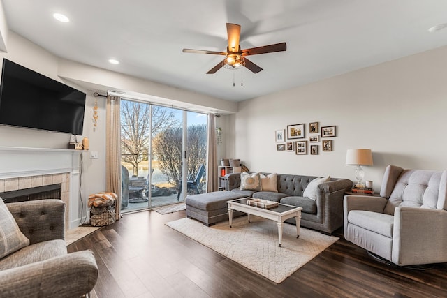 living room featuring recessed lighting, a fireplace, a ceiling fan, and dark wood-style flooring