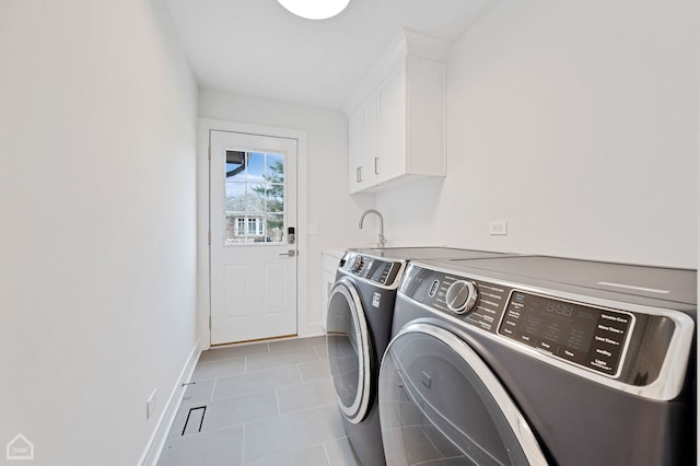 laundry room with tile patterned flooring, baseboards, washing machine and dryer, cabinet space, and a sink