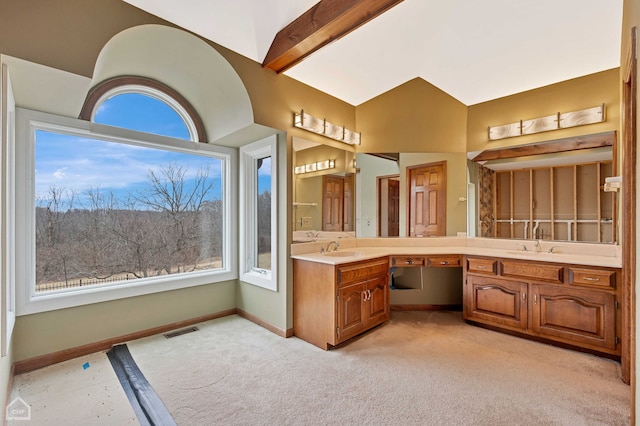 bathroom featuring baseboards, visible vents, double vanity, vaulted ceiling with beams, and a sink