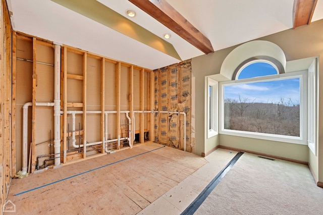 interior space featuring beam ceiling, visible vents, and baseboards