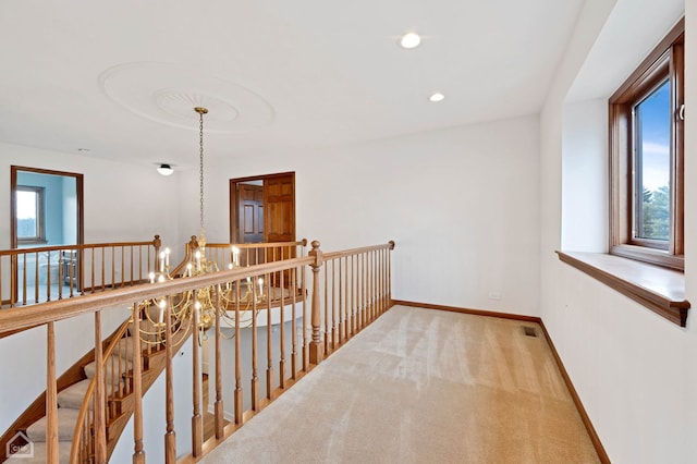 corridor featuring visible vents, baseboards, a chandelier, carpet flooring, and recessed lighting