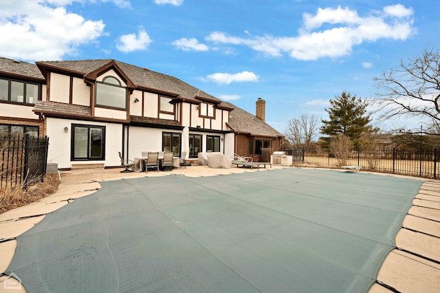 exterior space with stucco siding, a patio, a chimney, and fence