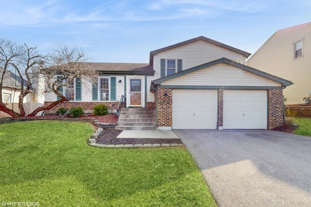 tri-level home with a garage, driveway, brick siding, and a front yard