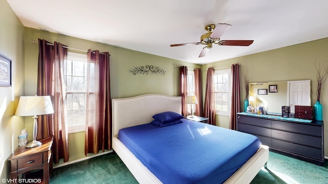 bedroom featuring ceiling fan, multiple windows, and carpet flooring