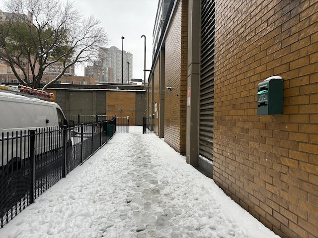 view of side of home featuring brick siding and fence