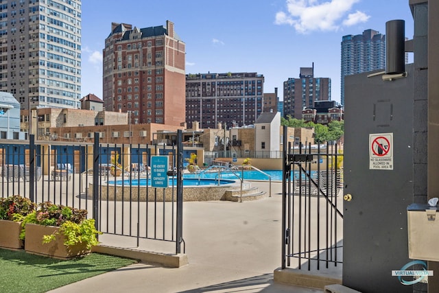 community pool with a view of city and fence