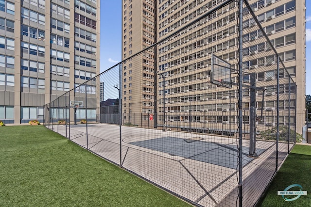 view of basketball court featuring community basketball court, fence, and a lawn