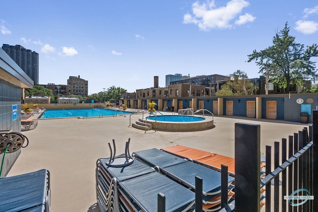 pool featuring a view of city and a patio area