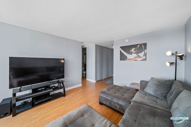 living area with baseboards and wood finished floors