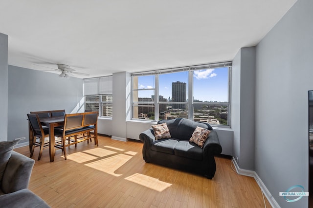 living area featuring light wood-type flooring, baseboards, and a city view