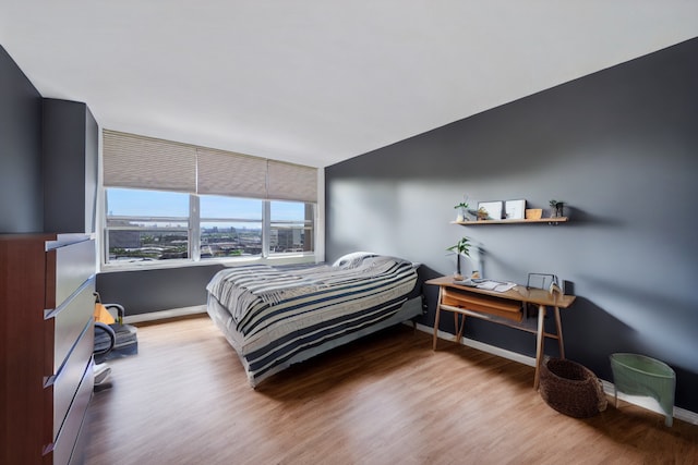 bedroom with wood finished floors and baseboards