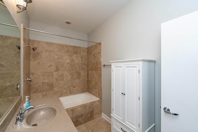 bathroom with tile patterned flooring, a sink, and tiled shower / bath combo