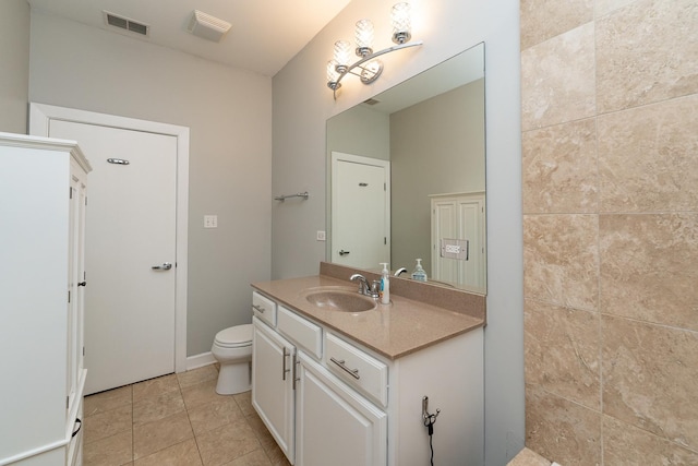 bathroom featuring visible vents, toilet, vanity, tiled shower, and tile patterned floors