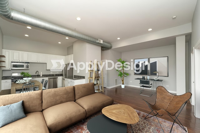 living room with visible vents, baseboards, dark wood-type flooring, and recessed lighting