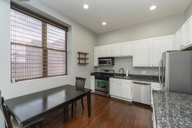 kitchen with white cabinetry, dark wood-style flooring, stainless steel appliances, and a sink