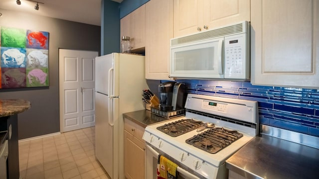 kitchen featuring stainless steel countertops, white appliances, tasteful backsplash, and light tile patterned flooring