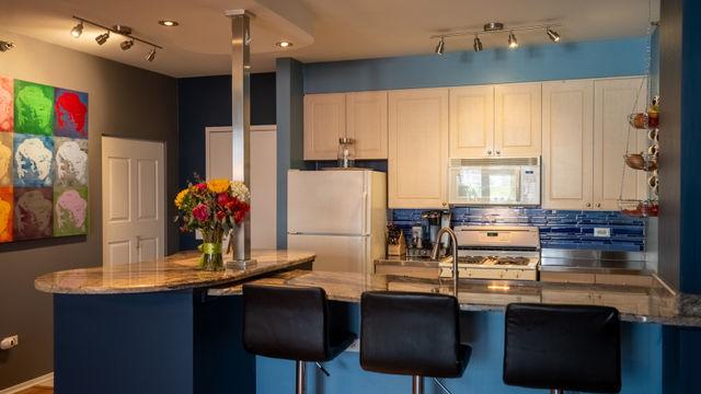 330 N Jefferson St Unit 603, Chicago, IL 60661 - kitchen featuring white appliances, track lighting, backsplash, and stone counters